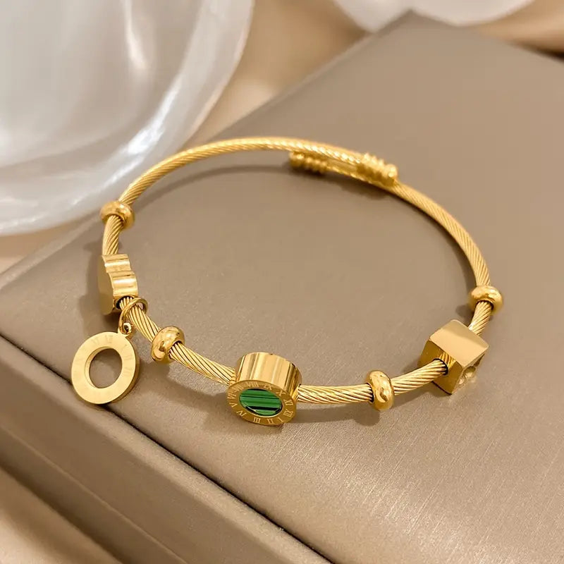 Guldfärgat armband med en grön ädelsten