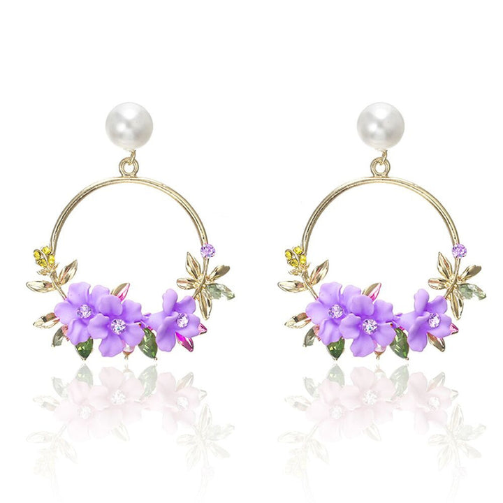 Eleganta örhängen i guld med blommor och pärlor