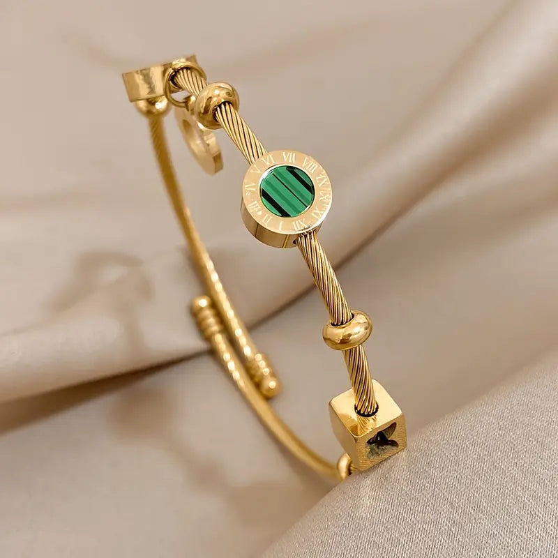 Guldfärgat armband med en grön ädelsten