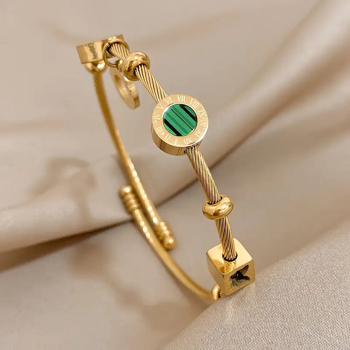 Guldfärgat armband med en grön ädelsten