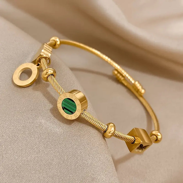 Guldfärgat armband med en grön ädelsten