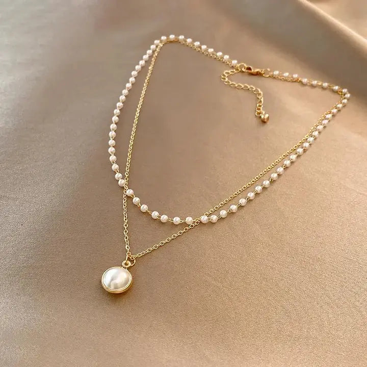 Halsband med guldfärgat pärlhänge